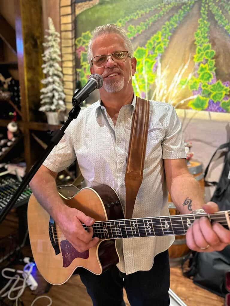 Musician Rob Olson playing guitar at UnWINED Wine & Beer Bar